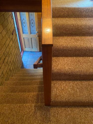 a set of stairs with a white door and a stair case at Wombat Mansion in Binalong Bay