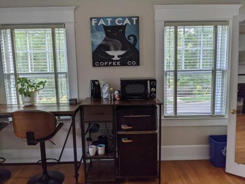 an office with a desk and a coffee sign on the wall at Sunny Efficiency In Historic Home in Durham
