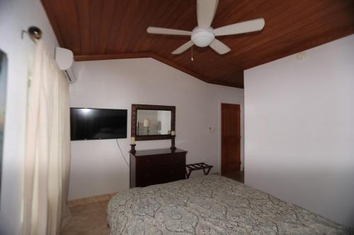 a bedroom with a ceiling fan and a bed at Oceanfront Resort-Style Oasis -Private Pool & Car in Grand Turk