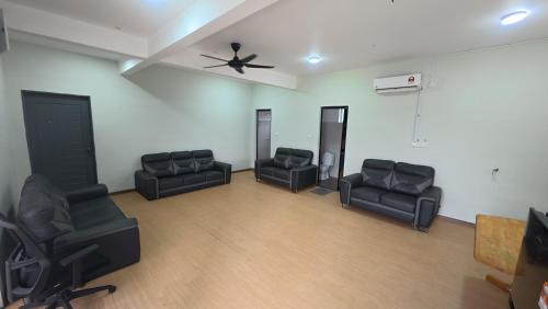 an empty room with black chairs and a ceiling fan at Villa with Titiwangsa Hill View in Kerling