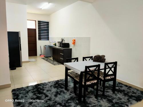 a dining room with a table and two chairs at NH Stay, Parit Buntar Perak in Parit Buntar