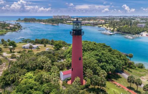 an aerial view of a red lighthouse on a hill next to the water at 4br Home W Guest Suite Pool Near Pga & Beach in Palm Beach Gardens