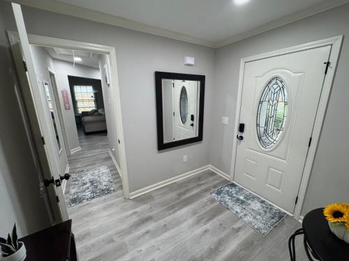 a living room with a white door and wood floors at Unwind in Winder in Winder