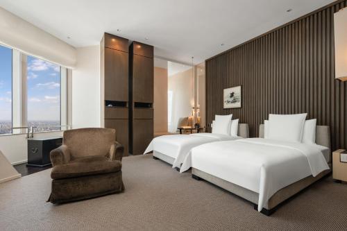 a hotel room with two beds and a chair at Park Hyatt Shanghai in Shanghai