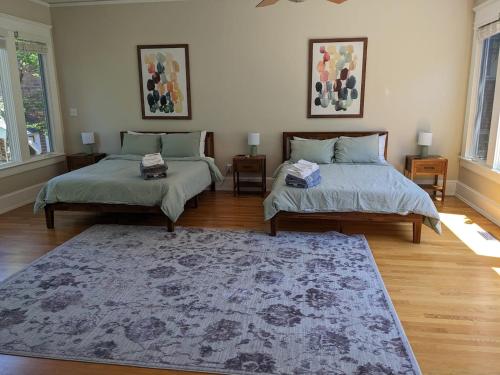 a living room with two beds and a rug at Luxurious 1BR in Grand Old Home in Durham