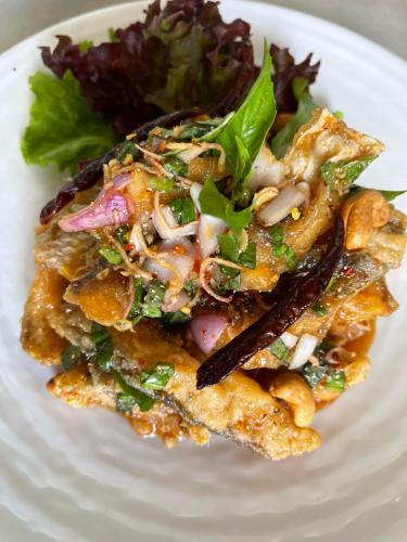 a white plate of food with a salad on it at Lailaresidence in Yala