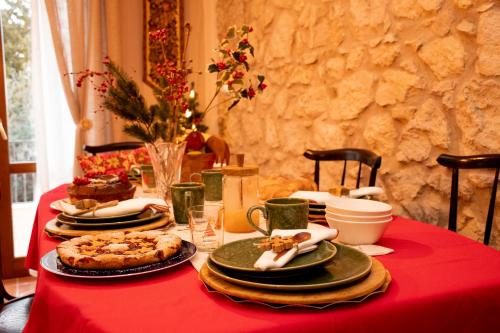 a table with a red table cloth with food on it at The Oaks in Spigno Saturnia