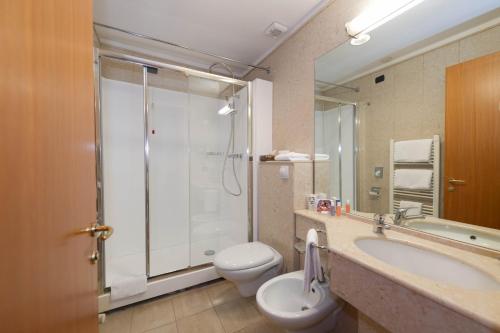 a bathroom with a shower and a toilet and a sink at Hotel Duomo in Orvieto