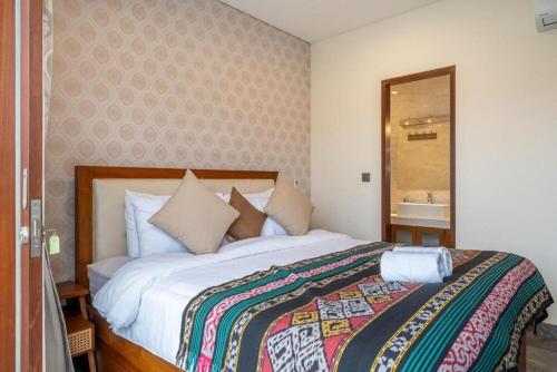 a bedroom with a bed and a mirror and a sink at Modern 5BR Luxury Villa with Pool & Rooftop - 100m from Sanur Beach in Sanur