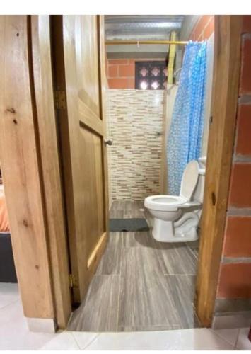 a bathroom with a toilet and a door open at Cabaña en San Rafael Cerca de Ríos y Naturaleza in San Rafael