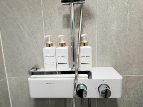 ein Badezimmer mit vier Flaschen Geruchsspender auf einem Waschbecken in der Unterkunft Busan #Gwanganri #Full Ocean #Healing in Busan