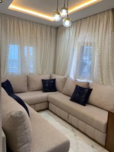 a living room with a couch and some windows at Appartement confortable à mdiq in M'diq