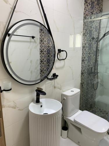 a bathroom with a sink and a mirror and a toilet at Appartement confortable à mdiq in M'diq