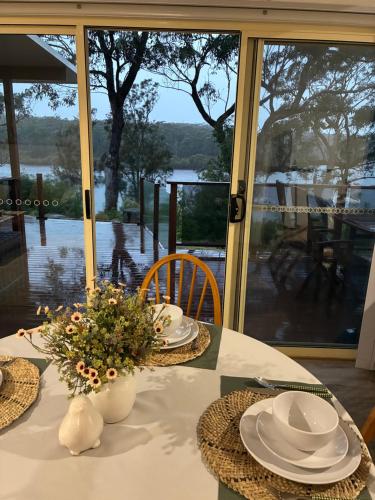 a table with plates and hats and flowers on it at Sussex Inlet Cillanti Retreat in Sussex inlet