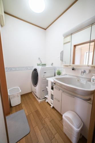 a bathroom with a sink and a washing machine at ArudenaiDay in Tokushima