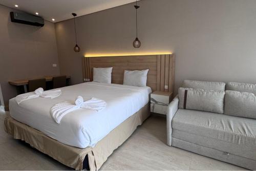 a bedroom with a large white bed and a couch at Chalé para 4 pessoas in Campina Grande do Sul