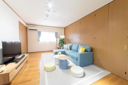 a living room with a blue couch and a table at ArudenaiDay in Tokushima