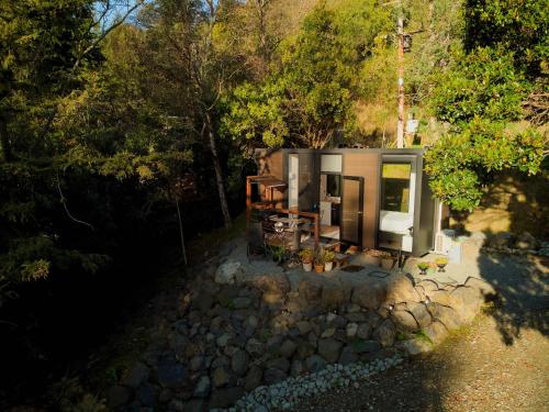a small shed with a table and chairs in a forest at Cosy Dell by Tiny Away in Herbert