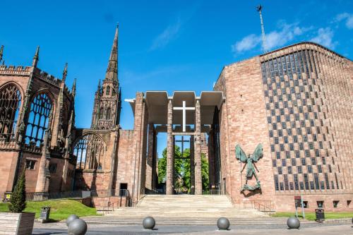 a church with a cross on the side of it at Landvue Stays, Modern, 2 bed apartment with free parking! in Coventry