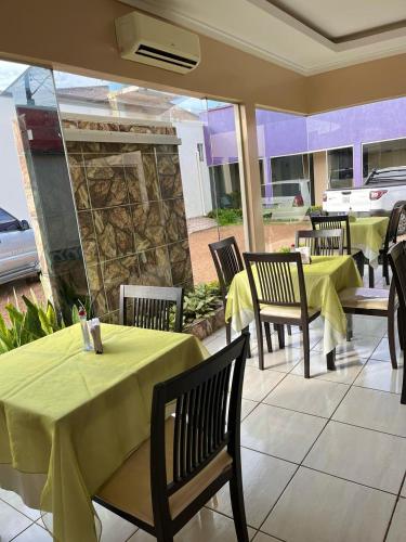 a restaurant with tables and chairs with yellow table cloth at Topázzio Hotel in Altamira