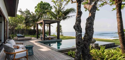 a villa with a swimming pool and the ocean at Regent Bali Canggu in Canggu