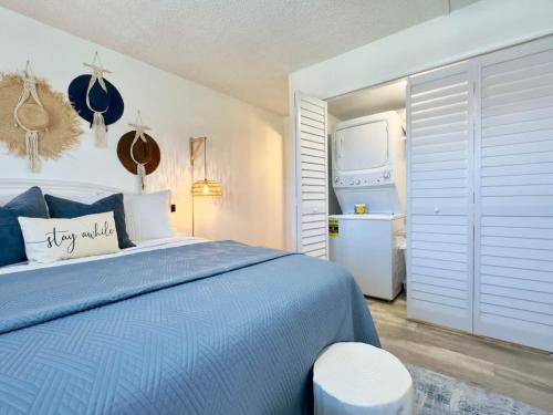 a bedroom with a blue bed and a refrigerator at Pier Pressure Beachfront Wpool in Cocoa Beach