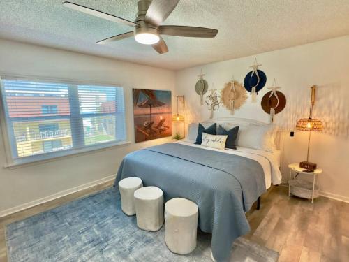a bedroom with a bed with a ceiling fan at Pier Pressure Beachfront Wpool in Cocoa Beach