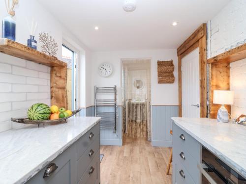 a kitchen with a bowl of fruit on the counter at Still Waters in Brixham