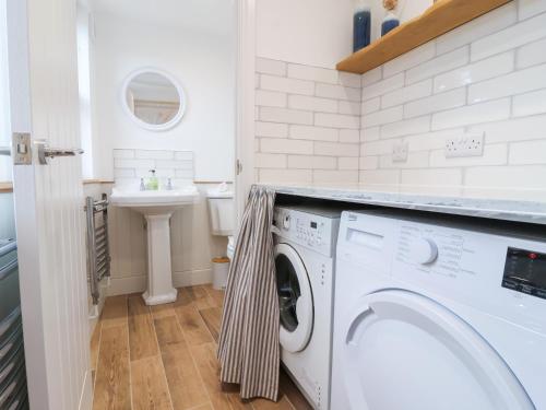 a laundry room with a washing machine and a sink at Still Waters in Brixham