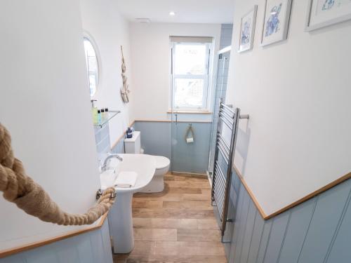 a bathroom with a sink and a toilet in it at Still Waters in Brixham
