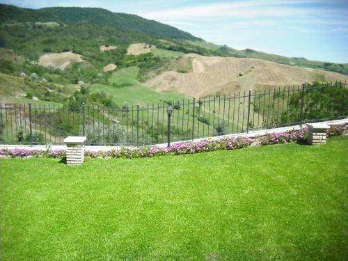 a fence with two benches in a field of grass at Cozy 2-Bed Apartment, Petrella in Petrella Guidi