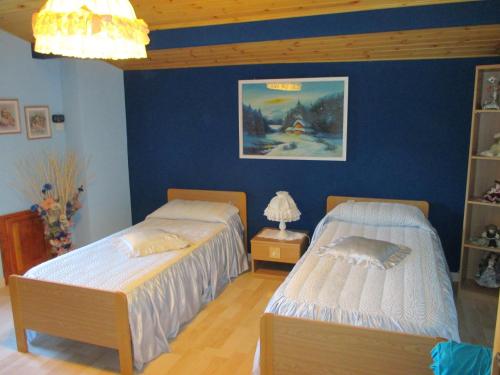 two beds in a room with blue walls at Cozy 2-Bed Apartment, Petrella in Petrella Guidi