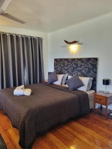 a bedroom with a large bed and a couch at Ocean Beach Bach Rarotonga in Rarotonga