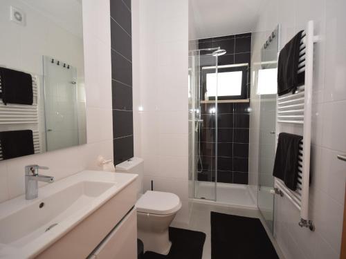 Un baño con inodoro, lavabo y ducha. en Holiday Home Nazaré Beach for Surfing, en Famalicão