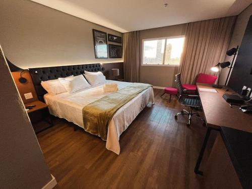 a hotel room with a bed and a desk at Quartos no QS Marista in Goiânia