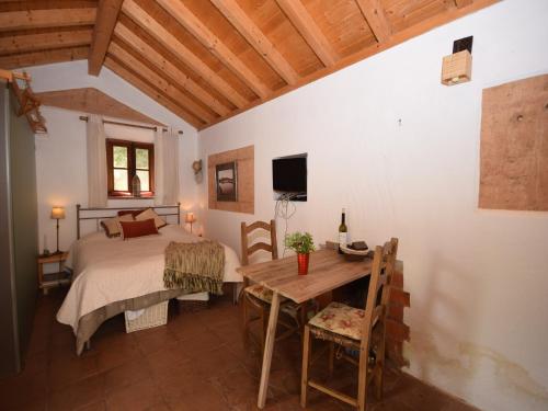 una camera da letto con un letto, un tavolo, un letto e una televisione di Cottage in São Luís near Costa Vicentina a São Luis