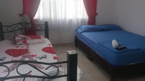 a small bedroom with two beds and a window at Hotel del oeste in Yopal