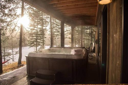 a jacuzzi tub in a house with the sun shining at Gleneagles Golf Course Retreat With Hot Tub in Columbia Falls