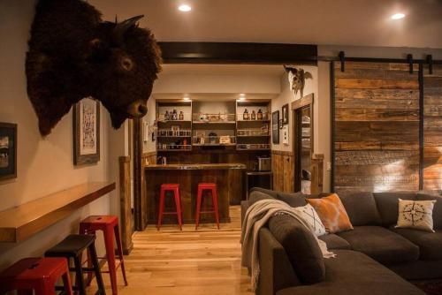 a living room with a couch and a bar at Gleneagles Golf Course Retreat With Hot Tub in Columbia Falls