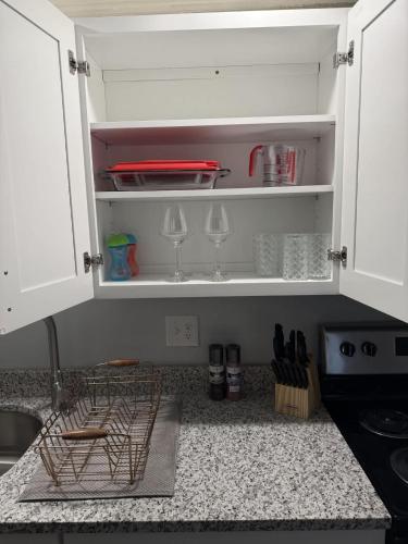 a kitchen counter with white cabinets and wine glasses at Barnacle Bay - Perfect Location Near The Beach in Hampton