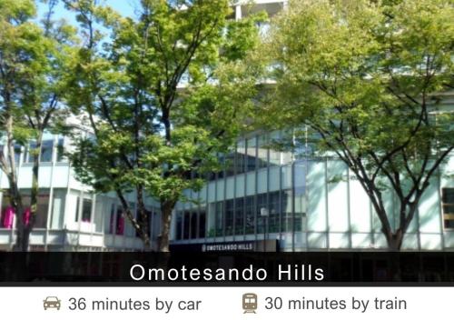 a white building with trees in front of it at Tokyu Stay Yoga in Tokyo