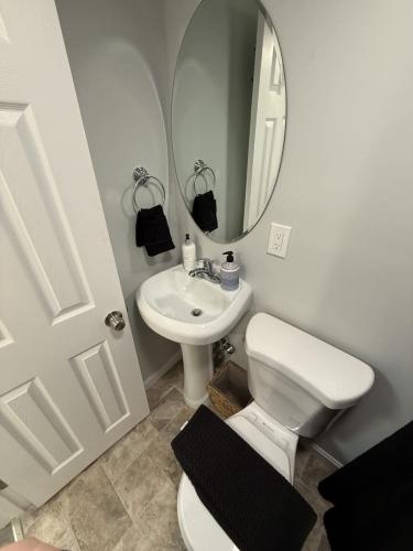 a bathroom with a toilet and a sink and a mirror at The Stuffed Quahog - Perfect Location Near Beach in Hampton
