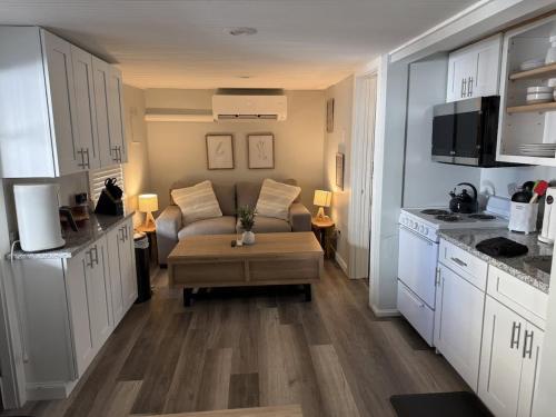 Una sala de estar con un sofá y una cocina. en The Lighthouse - Perfect Location Near Beach, en Hampton