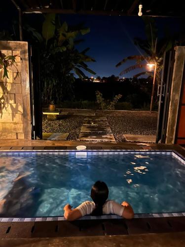 a person laying in a swimming pool at night at Ilona Huis in Patalan