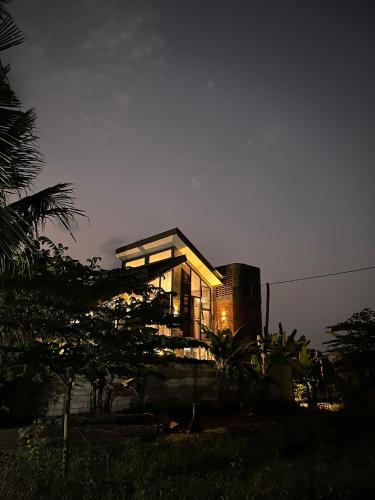 a house lit up at night with lights on at Ilona Huis in Patalan