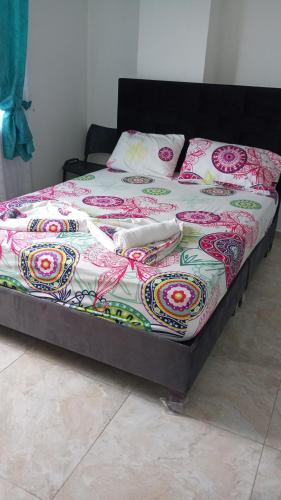 ein Bett mit einer bunten Decke und Utensilien darauf in der Unterkunft Hotel del oeste in Yopal
