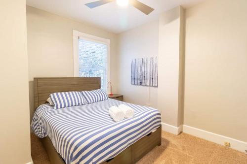a bedroom with a bed with a blue and white striped sheets at Walkable And Cozy German Village Hauspets Ok in Columbus