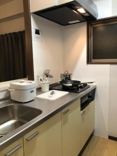 a kitchen with a sink and a counter top at Alphabed広島平和大通り in Hiroshima