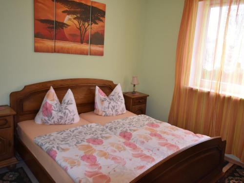 une chambre avec un lit avec une couette fleurie dans l'établissement Boiensdorf Beachside Bungalow, à Boiensdorf