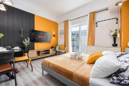 una camera da letto con un letto, una scrivania e una TV di Stylish Condo Near Airport- Poolview Amani Grand a Mactan Cebu International